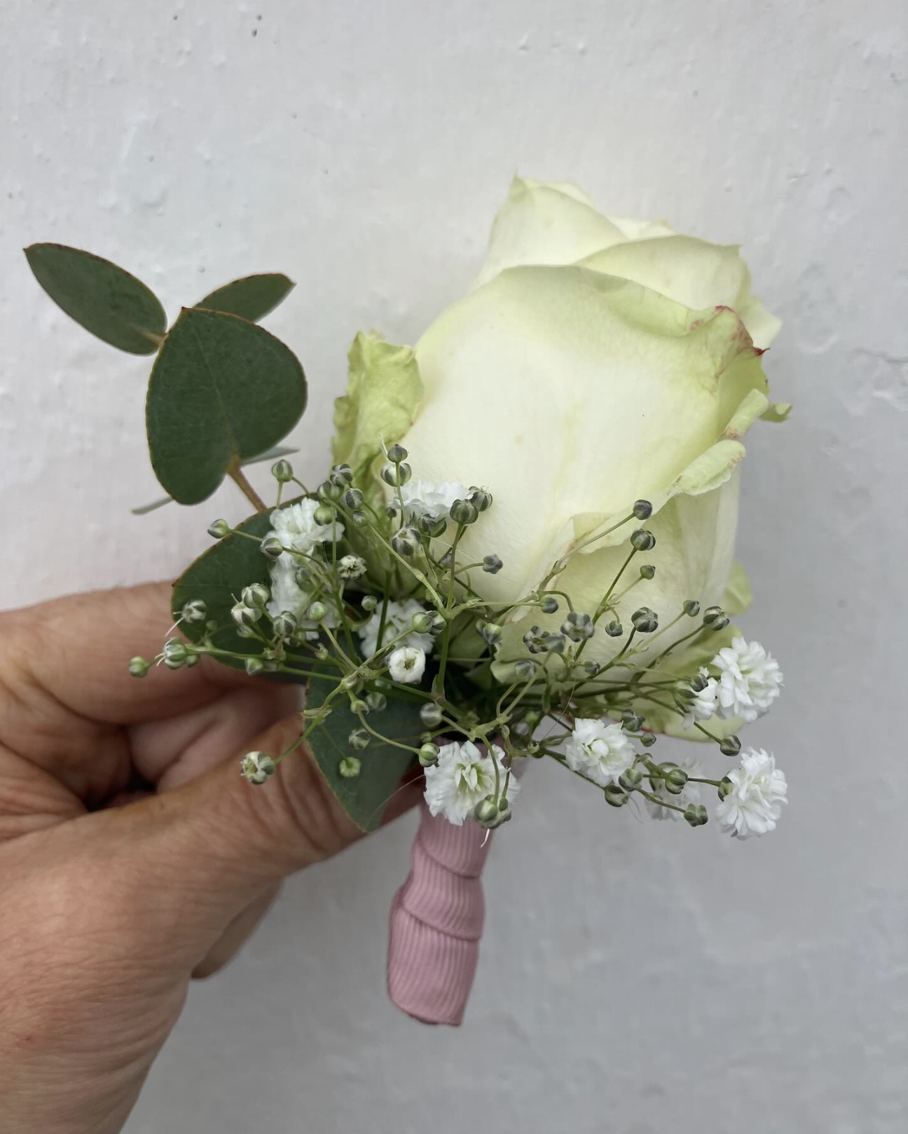 Knaphulsblomst til brudgom med hvid rose, eukalyptus og brudeslør – enkelt og elegant